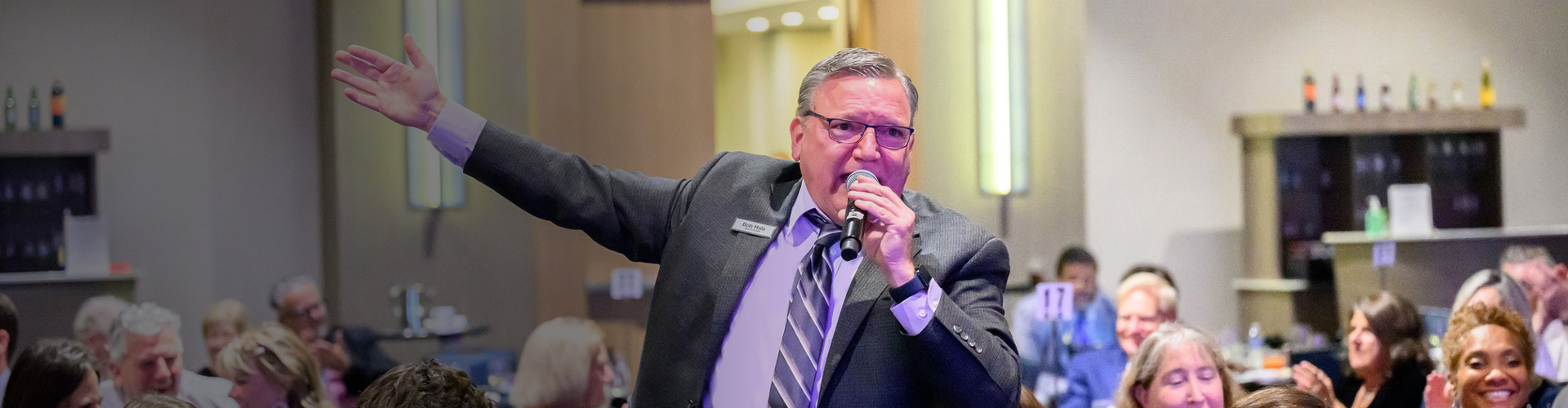 bob hale announcing the winning bid during a nonprofit organization's fundraiser