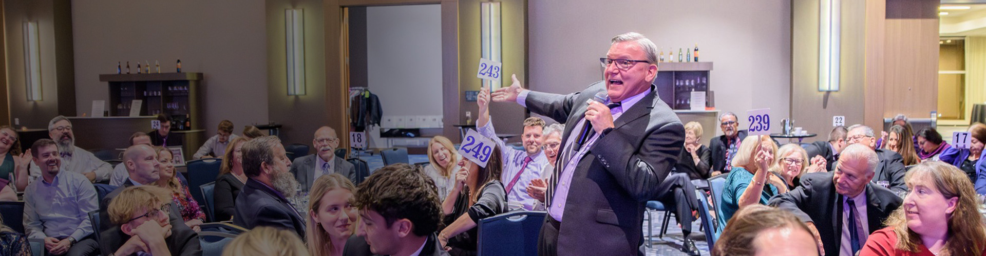 bob hale increasing the bid after a donor raises their paddle during an auction